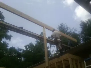 Carpenter setting a ridge beam over a new addition frame — Ice Dam Removal by Roofing Brothers in Buhler
