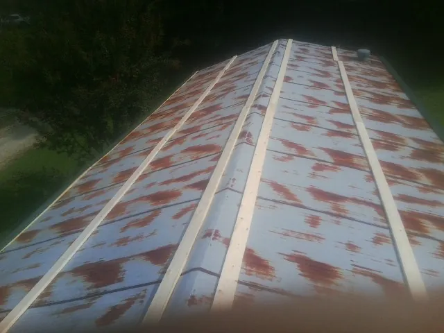 Rusted metal roof panels with new wood purlins before replacement — Storm Damage Roof Repair in Buhler by Roofing Brothers