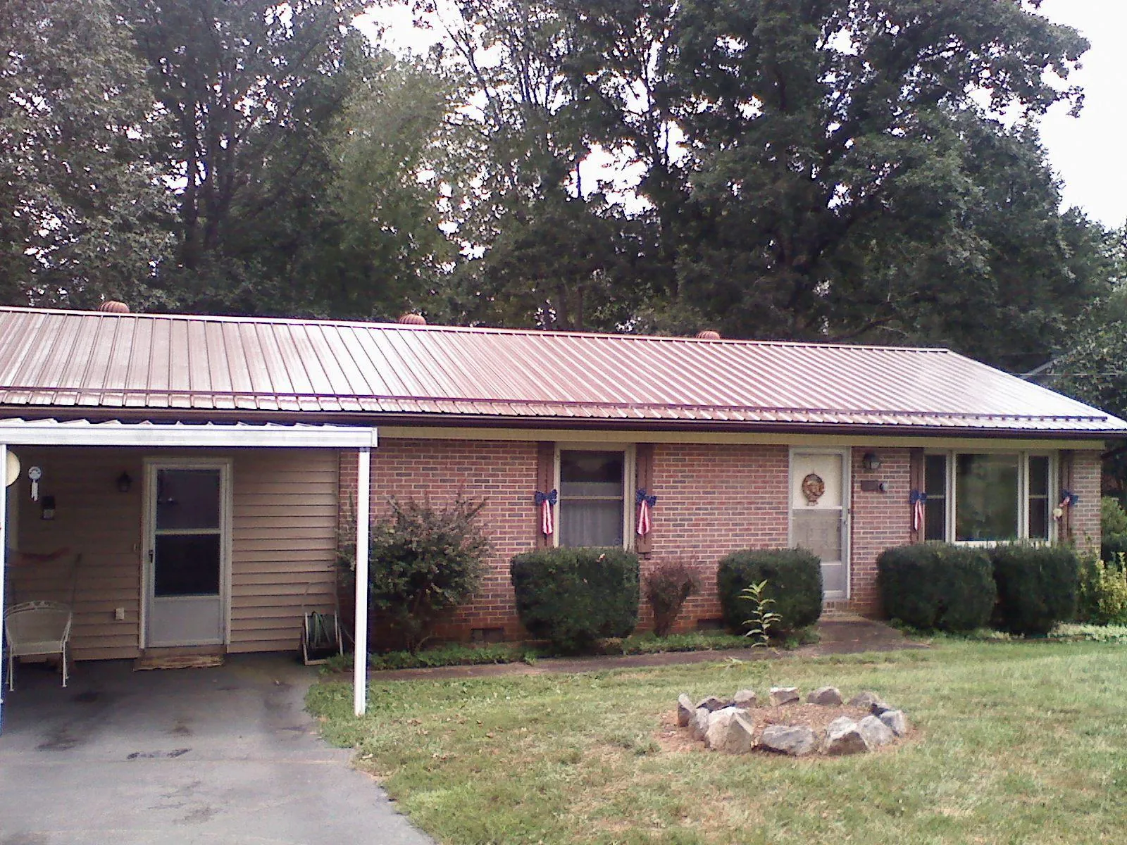 Bronze metal roof and carport on a brick ranch home — Roof Repair work by our crew in Buhler