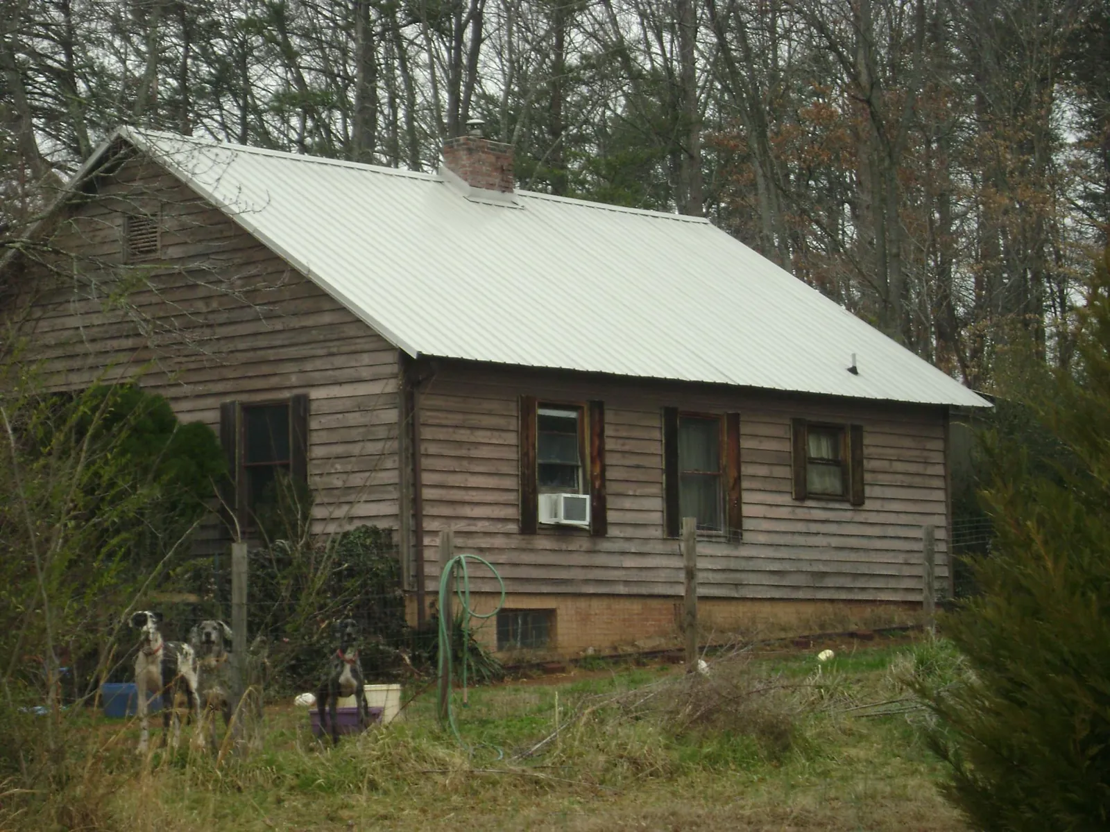 White metal roof on an old wood sided farmhouse, from a Asphalt Shingle Roof Repair job in Buhler